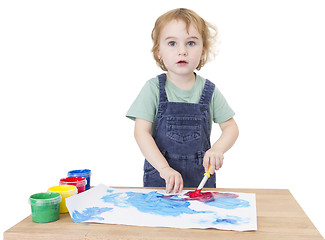 Image showing cute girl painting on small desk looking to camera
