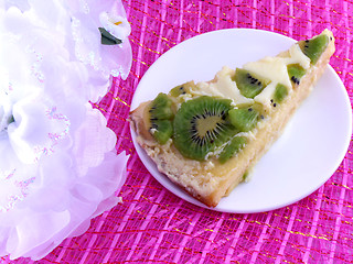 Image showing kiwi tasty cake close up at plate with white flowers