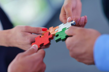 Image showing Group of business people assembling jigsaw puzzle