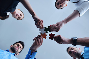 Image showing Group of business people assembling jigsaw puzzle