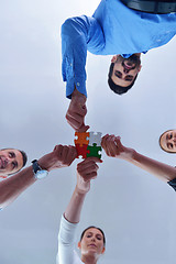 Image showing Group of business people assembling jigsaw puzzle