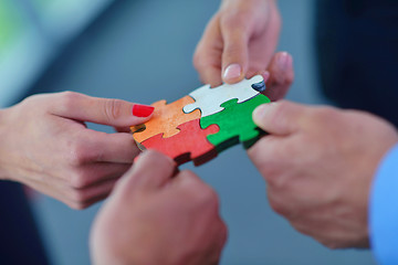 Image showing Group of business people assembling jigsaw puzzle