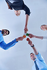 Image showing Group of business people assembling jigsaw puzzle