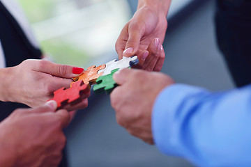 Image showing Group of business people assembling jigsaw puzzle