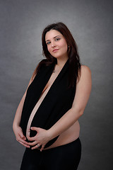 Image showing beautiful pregnant young woman tenderly holding her tummy