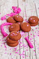 Image showing fresh chocolate cookies, coffee beans, pink ribbons and confetti