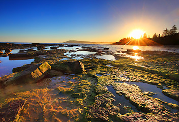 Image showing Golden Sunrays stretch across the reefs at sunset