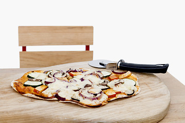 Image showing pizza with cutter on small desk