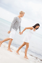 Image showing Couple holding hands while walking on the beach