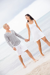 Image showing Couple holding hands while walking on the beach