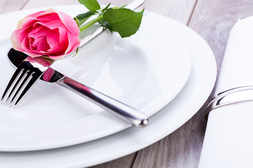 Image showing Table setting with a single pink rose