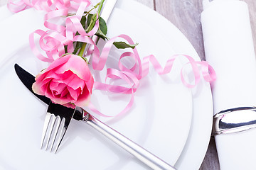 Image showing Table setting with a single pink rose