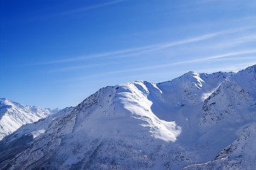 Image showing Snowy sunlight mountains, view from off piste slope