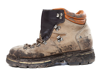 Image showing Old trekking boot in mud. Side view.