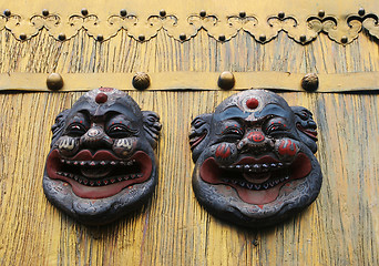 Image showing Asian masks on a gold door