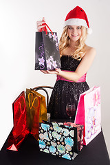 Image showing Blond woman in santa hat with shopping bags