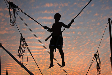 Image showing Boy hanging in the air with beautiful sky in background