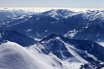 Image showing Snowy mountains and off-piste slope in morning haze