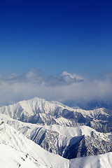 Image showing Winter snowy mountains and blue sky with clouds