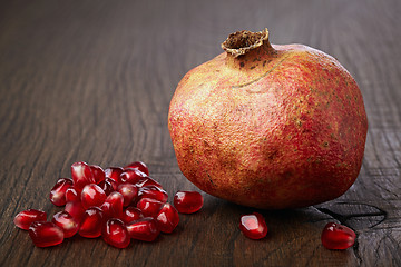Image showing Pomegranate and seeds on wooden table