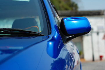 Image showing Right side mirror of shiny blue car