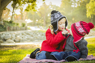 Image showing Little Girl with Baby Brother Wearing Coats and Hats Outdoors
