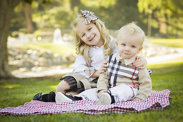 Image showing Sweet Little Girl Hugs Her Baby Brother at the Park
