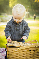 Image showing Blonde Baby Boy Opening Picnic Basket Outdoors at the Park