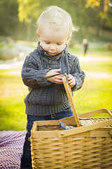 Image showing Blonde Baby Boy Opening Picnic Basket Outdoors at the Park