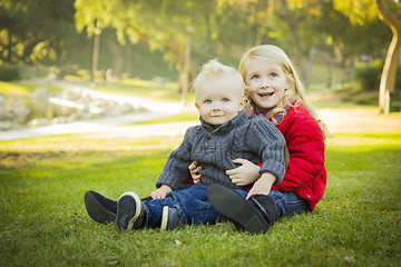 Image showing Little Girl with Baby Brother Wearing Coats at the Park
