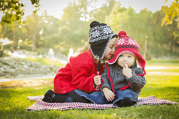 Image showing Little Girl Whispers A Secret to Baby Brother Outdoors