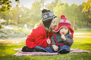 Image showing Little Girl Whispers A Secret to Baby Brother Outdoors