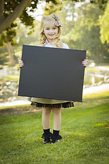 Image showing Cute Little Blonde Girl Holding a Black Chalkboard Outdoors
