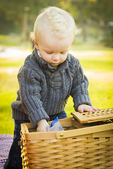 Image showing Blonde Baby Boy Opening Picnic Basket Outdoors at the Park