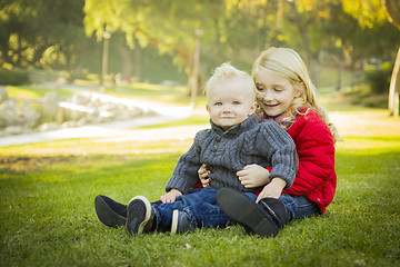 Image showing Little Girl with Baby Brother Wearing Coats at the Park
