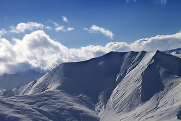 Image showing Off piste slope in evening with sunlit clouds