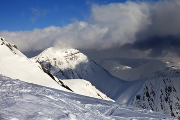 Image showing Off-piste slope and sunlit mountains in clouds