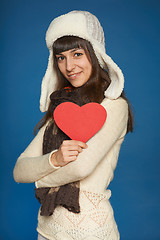 Image showing Winter woman in warm clothing giving heart shape