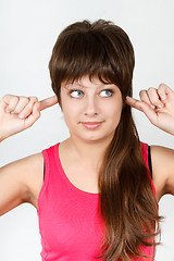 Image showing Young attractive girl covers her ears