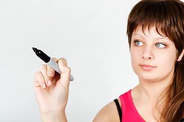 Image showing Young attractive girl writing in marker