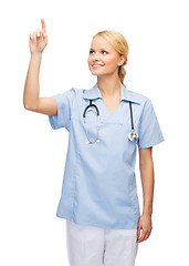 Image showing smiling doctor or nurse pointing to something