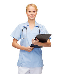 Image showing smiling female doctor or nurse with clipboard