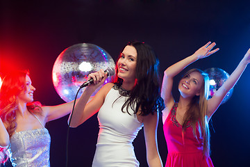 Image showing three smiling women dancing and singing karaoke