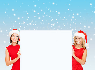 Image showing women in santa helper hats with blank white board