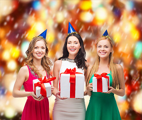 Image showing three smiling women in blue hats with gift boxes