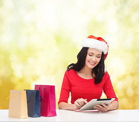 Image showing smiling woman with shopping bags and tablet pc