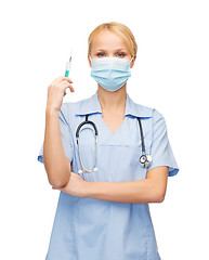 Image showing female doctor or nurse in mask holding syringe