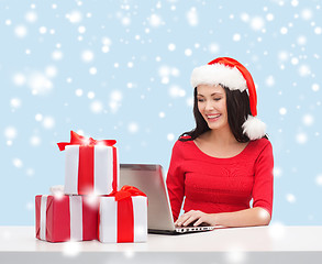 Image showing woman with gift boxes and laptop computer