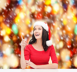 Image showing woman in santa helper hat pointing to something