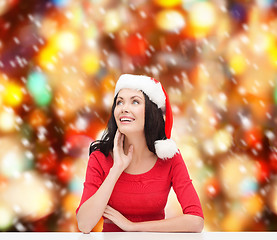 Image showing surprised woman in santa helper hat looking up